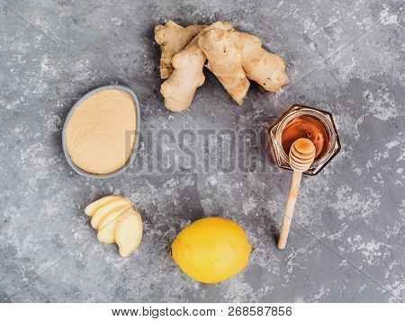 Top View Of Ginger Slice, Ginger Root, Ginder Powder, Lemon And Honey On Gray Concrete Background. H
