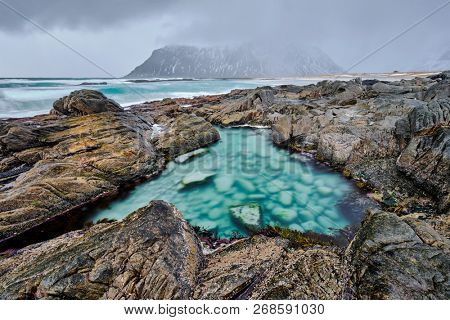 Rocky coast of fjord of Norwegian sea in winter. Lofoten islands, Norway