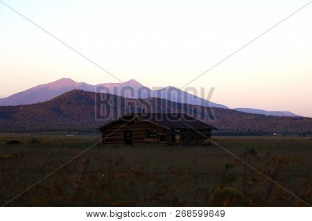Old House In Arizona Against The Backdrop Of The Mountains During Sunset.