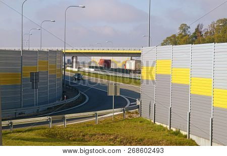 The Road Is Protected Against Noise Emission By Noise-absorbing Barrier (also Called A Soundwall, No