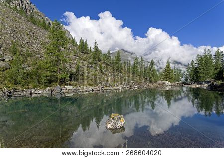 Reflection Of The Shore Of The Lake In The Watery Surface. The Large (lower) Shavlinsky Lake. Altai 