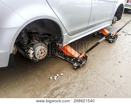 The Car Is At The Tire Shop. Under The Jack The Car In Car-care Center. The Car With The Removed Whe