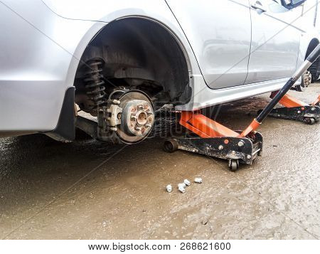 The Car Is At The Tire Shop. Under The Jack The Car In Car-care Center. The Car With The Removed Whe