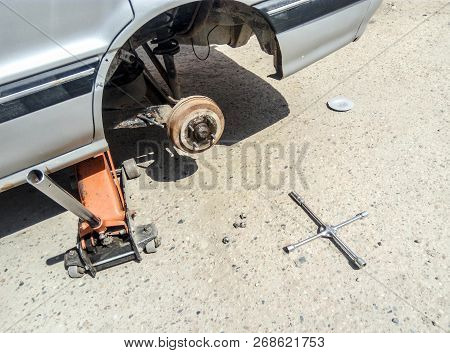The Car Is At The Tire Shop. Under The Jack The Car In Car-care Center. The Car With The Removed Whe