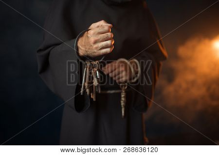 Medieval monk holds a bunch of keys in hands