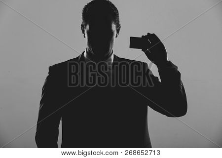 Silhouette Of Man, Businessman Or Manager Holding Business Or Bank Card In Blue Formal Suit On Grey 