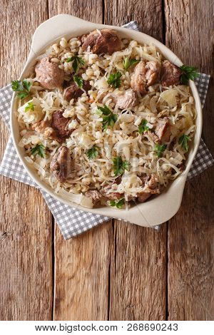 Delicious Traditional Estonian Mulgikapsas  Stewed Pork With Sauerkraut And Barley Close-up In A Pan