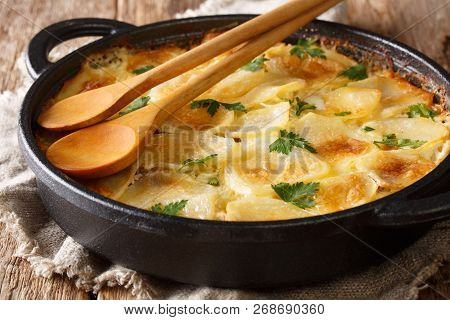 Delicious Finnish Baked Potatoes With Anchovy Fillets, Onions And Heavy Cream Close-up. Horizontal