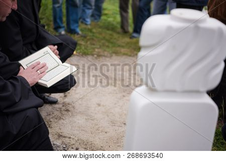 quran holy book reading by imam  on islamic funeral with white thumb stones graweyard background