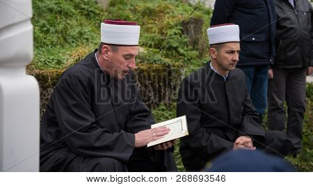quran holy book reading by imam  on islamic funeral with white thumb stones graweyard background