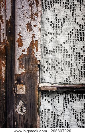 Detail of old window frame with knitting needlework curtain