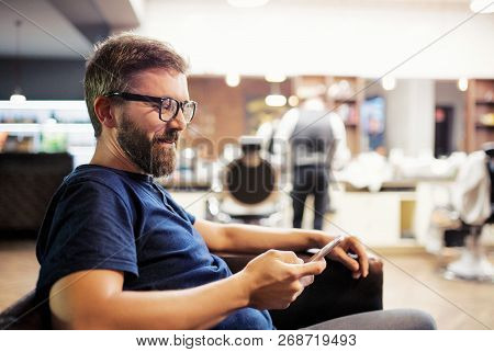 Hipster Man Client Visiting Haidresser And Hairstylist In Barber Shop, Waiting.
