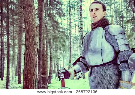Knight In Armor And With A Sword In The Middle Of A Winter Forest. Vintage Military Uniform.