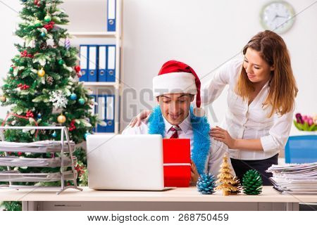 Colleagues exchaing christmas presents in office