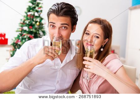 Young couple celebraring christmas with champagne