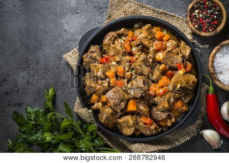 Beef Stew With Vegetables In Iron Pan On Black Background. European Cuisine. Top View.