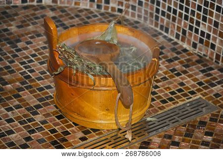 Wooden Scoop And Tub With Hot Water And Eucalyptus Broom In A Bathhouse
