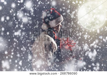 Christmas Gift Concept. Man In Santa Hat Bring Gift For You. Attractive Man Hold Box.  Christmas And
