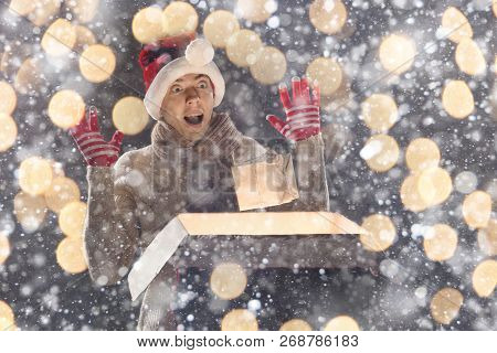 Christmas Gift Concept. Man In Santa Hat Bring Gift For You. Attractive Man Hold Box.  Christmas And