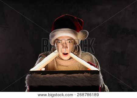 Christmas Gift Concept. Man In Santa Hat Bring Gift For You. Attractive Man Hold Box.  Christmas And