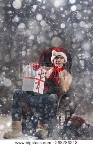 Christmas Gift Concept. Man In Santa Hat Bring Gift For You. Attractive Man Hold Box.  Christmas And