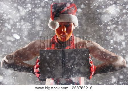 Christmas Gift Concept. Man In Santa Hat Bring Gift For You. Attractive Man Hold Box.  Christmas And
