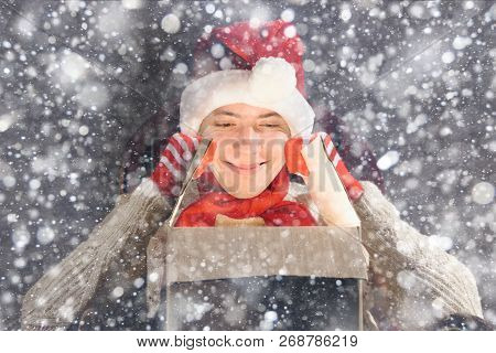 Christmas Gift Concept. Man In Santa Hat Bring Gift For You. Attractive Man Hold Box.  Christmas And