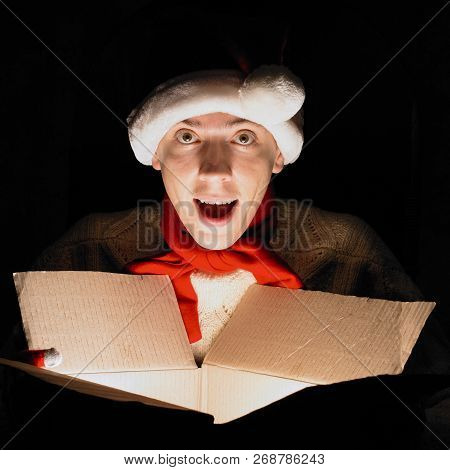 Christmas Gift Concept. Man In Santa Hat Bring Gift For You. Attractive Man Hold Box.  Christmas And