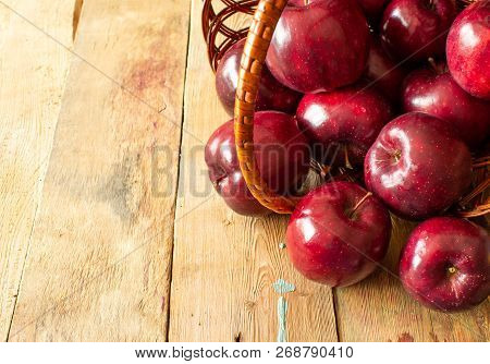 Red Juicy Ripe Apples In A Basket On A Wooden Background
