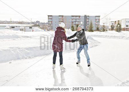 Couple In Sunny Winter Nature Ice Skating