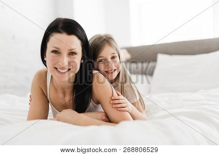 Mother And Daughter Enjoy In Bed At Home