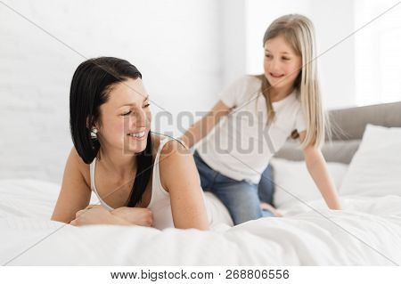 Mother And Daughter Enjoy In Bed At Home