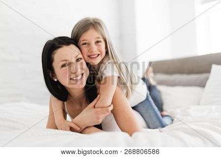 Mother And Daughter Enjoy In Bed At Home