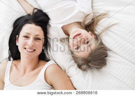 Mother And Daughter Enjoy In Bed At Home