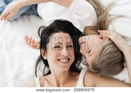 Mother And Daughter Enjoy In Bed At Home