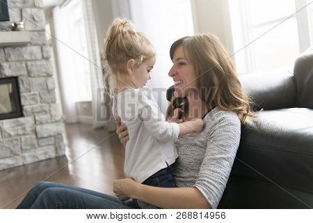 Happy Mother With Her Baby Daughter In The Living Room At Home