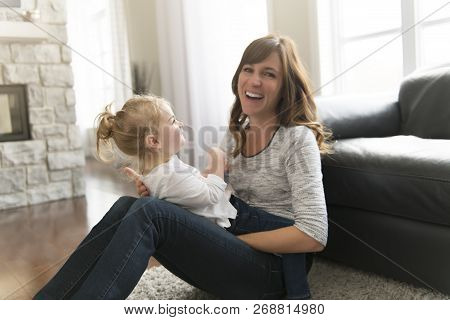 Happy Mother With Her Baby Daughter In The Living Room At Home