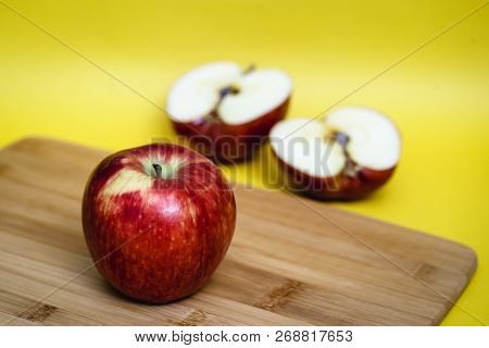 Red Apple Next To Slices Of Another Apple.