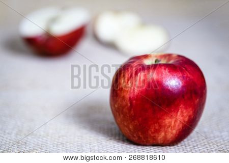 Big Red Apple Next To Slices Of Another Apple.