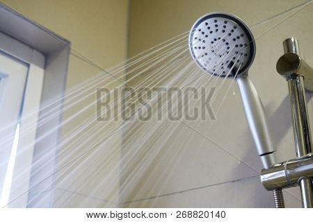 shower head in bathroom with water drops flowing            