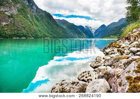 Beautiful Lake In The Mountains And View Of Briksdal Glacier In Norway. Summer Landscape