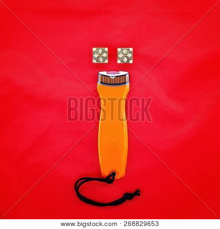 Gold Cuff Links Above A Plastic Torch