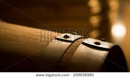 Old Wine Barrels In A Wine Cellar. 
Stacked Up Wine Bottles In The Cellar, Dusty But Tasty.