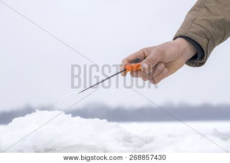Winter Fishing Concept. Hand Of Fisherman With Specialised Rod Above Snowy Ice.