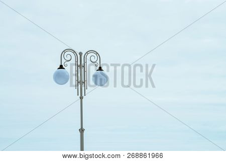 White Pillar In Vintage Style With Double Suspended Lantern In Sphere Form On Blue Sky Background. S