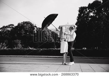 Young Couple Jump Up With Black Upbrella. Lovely Cuople Have Fun