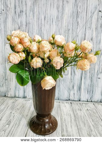 Cream Peony Roses In A Vase Closeup On A Wooden Background. Work In A Flower Shop. Bouquet Of Roses