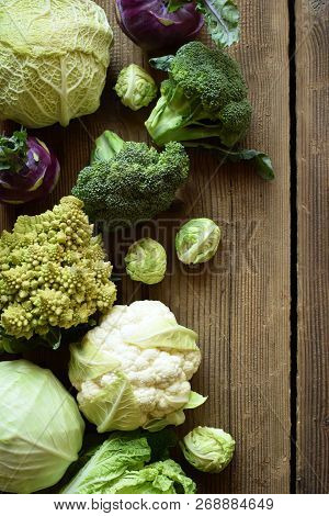 Different Varieties Of Cabbages On Wooden Background. Organic Fresh Vegetables - Cauliflower, Kohlra