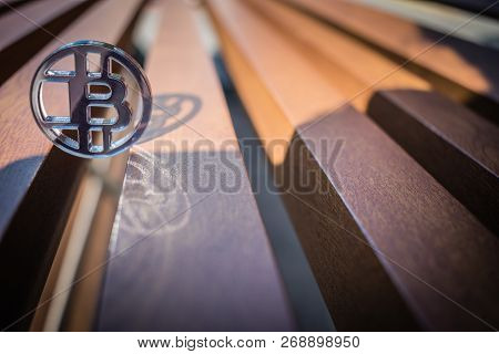 Plastic See Thru Bit Coin On Wooden Background And Lines.