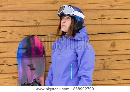 Portrait Woman With Snowboard And Hat And Splitboard Near Wooden Wall